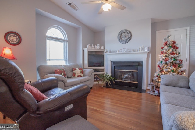 living room featuring ceiling fan, wood-type flooring, and vaulted ceiling