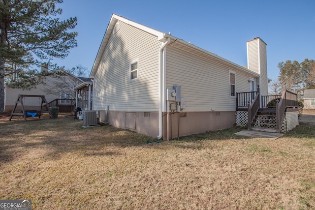 view of side of property with a lawn, central AC unit, and a deck