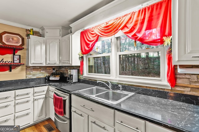 kitchen featuring decorative backsplash, ornamental molding, sink, light hardwood / wood-style floors, and white cabinetry