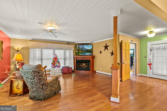 living room with hardwood / wood-style flooring, ceiling fan, and ornamental molding