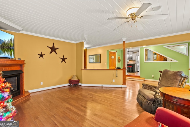 living room with crown molding, ceiling fan, and wood-type flooring