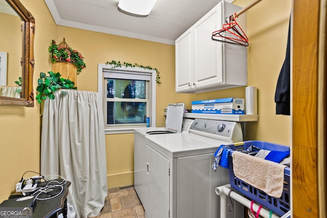 laundry area with washer and dryer, cabinets, and ornamental molding