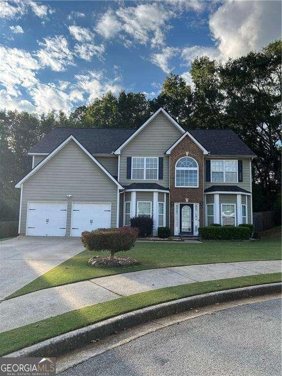 view of front of house with a garage and a front lawn