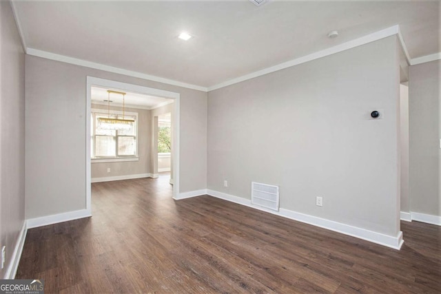 empty room with dark hardwood / wood-style flooring and crown molding