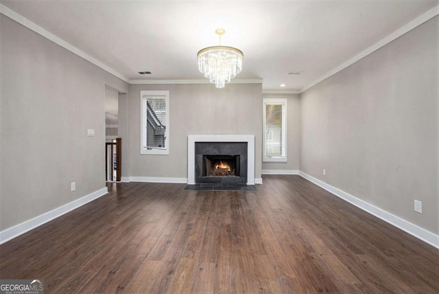 unfurnished living room featuring crown molding, dark hardwood / wood-style flooring, and an inviting chandelier