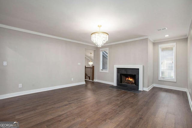 unfurnished living room featuring dark hardwood / wood-style flooring, an inviting chandelier, and ornamental molding