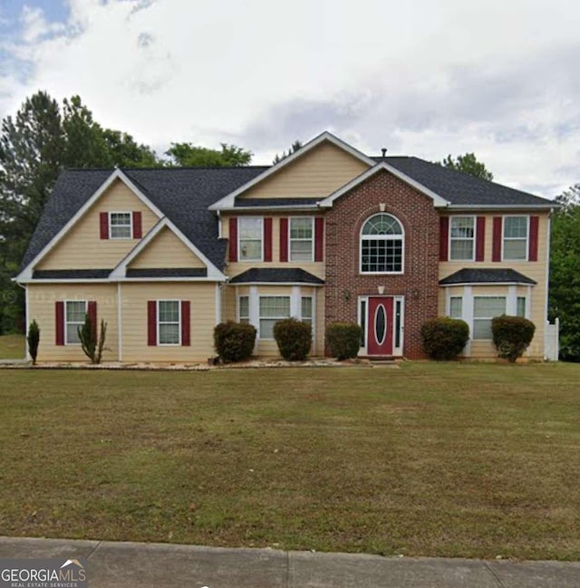 colonial inspired home featuring a front lawn