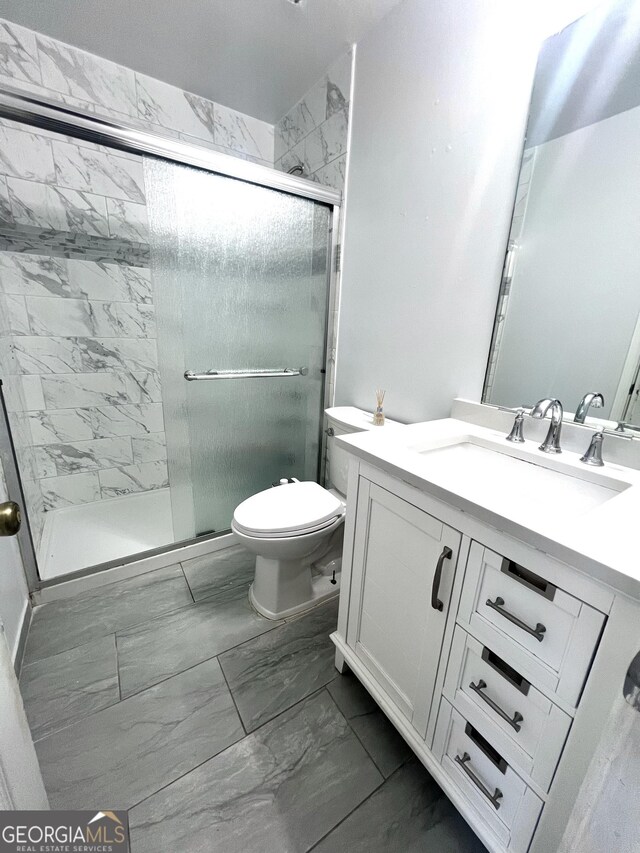 bathroom featuring vanity, toilet, and walk in shower