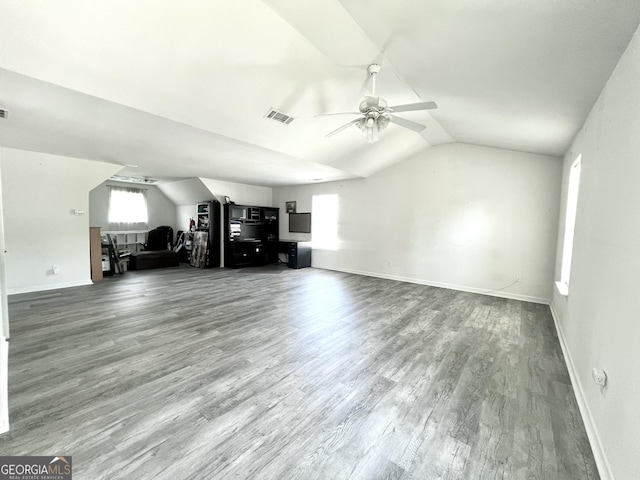 unfurnished living room with hardwood / wood-style flooring, vaulted ceiling, and ceiling fan