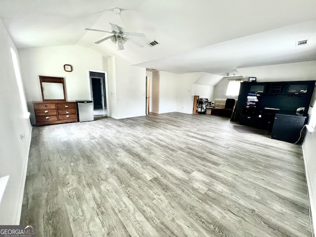 living room featuring ceiling fan, light hardwood / wood-style floors, and vaulted ceiling