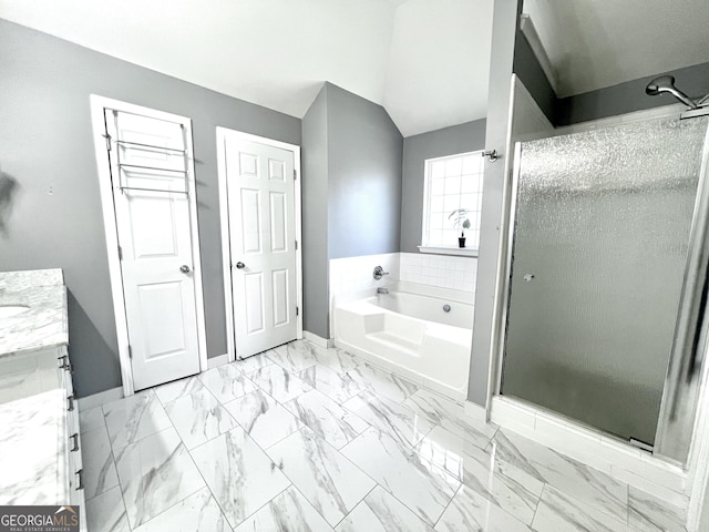 bathroom featuring separate shower and tub, vanity, and vaulted ceiling