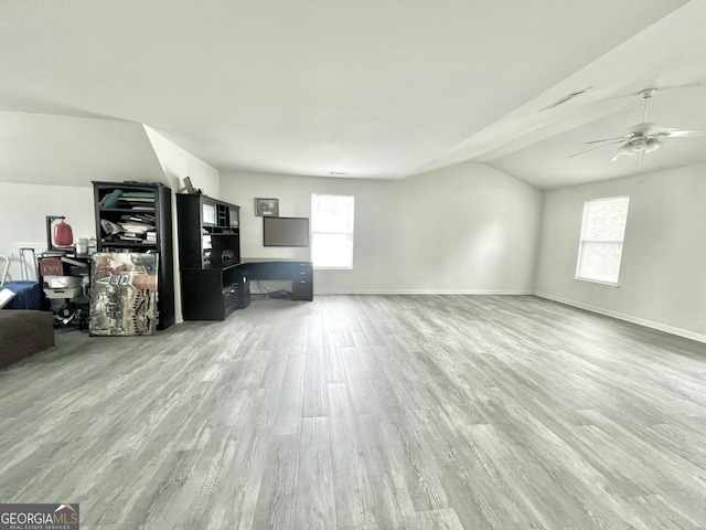 unfurnished living room with hardwood / wood-style flooring, plenty of natural light, ceiling fan, and lofted ceiling