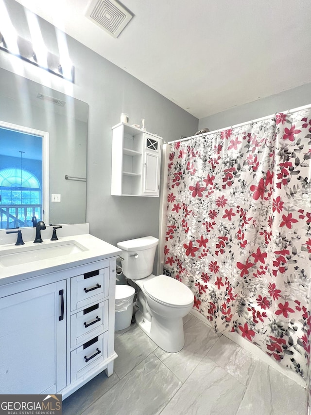 bathroom with vanity, a shower with shower curtain, and toilet