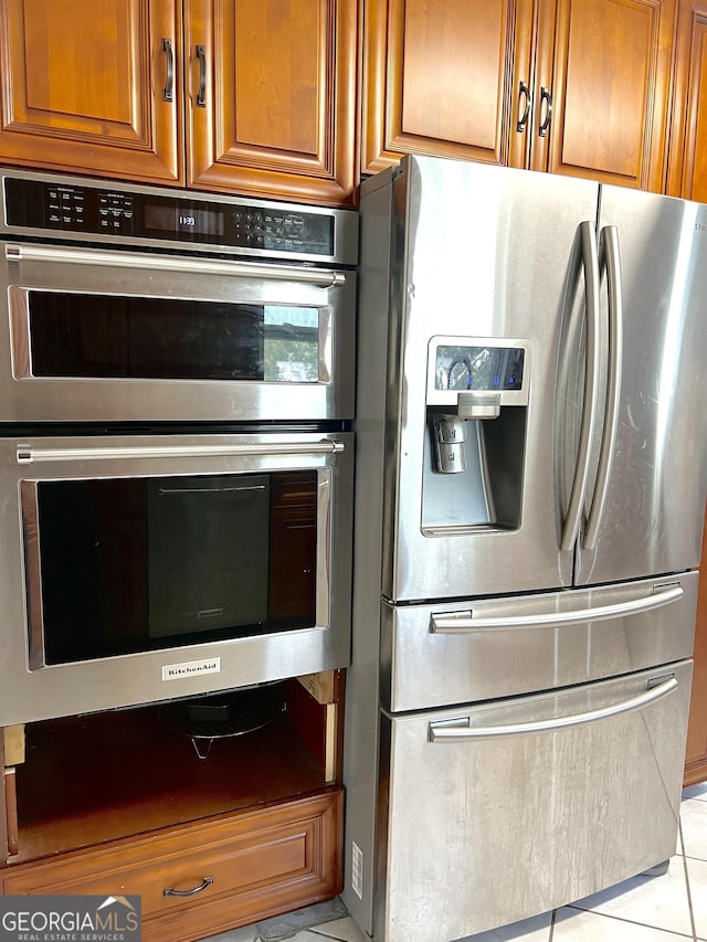 kitchen featuring light tile patterned flooring and stainless steel appliances