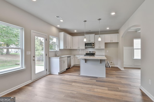 kitchen with white cabinetry, stainless steel appliances, and a kitchen island