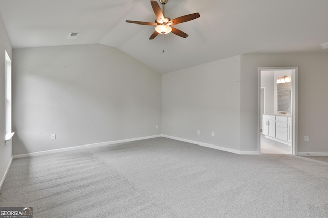 carpeted empty room featuring vaulted ceiling and ceiling fan