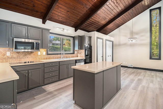 kitchen with sink, black appliances, lofted ceiling with beams, decorative light fixtures, and light hardwood / wood-style flooring