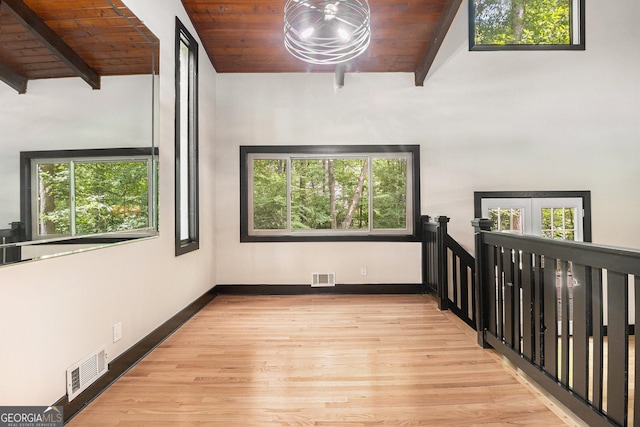 interior space featuring vaulted ceiling with beams, wooden ceiling, and light wood-type flooring