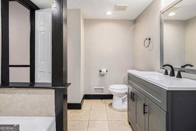 bathroom with toilet, vanity, a tub to relax in, and tile patterned floors