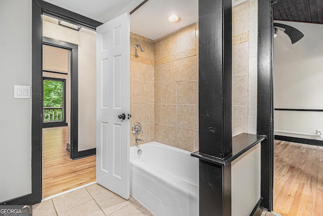 bathroom featuring wood-type flooring and tiled shower / bath