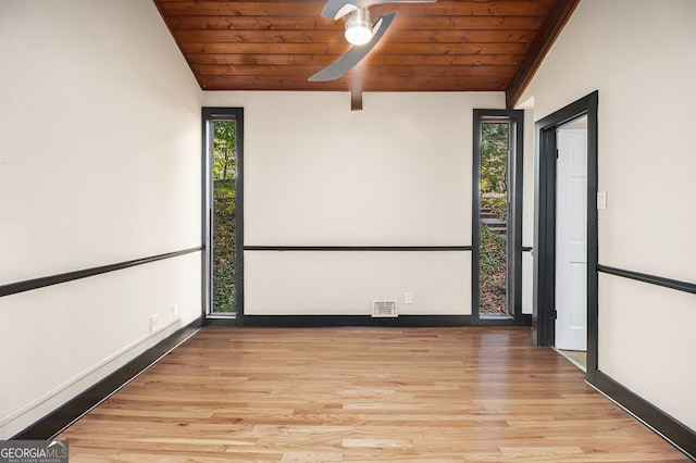 unfurnished room featuring vaulted ceiling with beams, a wealth of natural light, wood ceiling, and light wood-type flooring