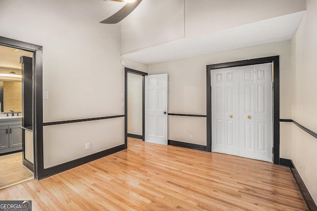 unfurnished bedroom featuring ceiling fan, light wood-type flooring, and sink