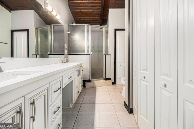 bathroom with tile patterned flooring, vanity, toilet, and an enclosed shower