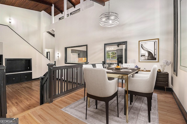 dining area featuring beam ceiling, high vaulted ceiling, wooden ceiling, and hardwood / wood-style flooring