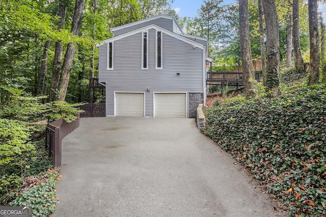 view of property exterior featuring a garage and a wooden deck