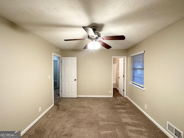 unfurnished bedroom featuring carpet, a textured ceiling, and ceiling fan