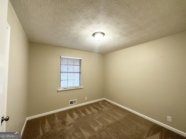 carpeted spare room featuring a textured ceiling