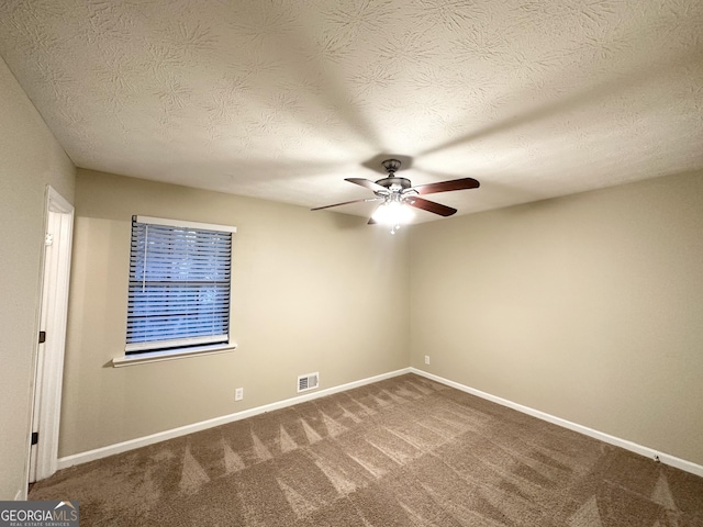 carpeted spare room featuring ceiling fan and a textured ceiling