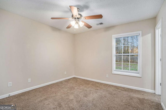 carpeted empty room featuring a textured ceiling