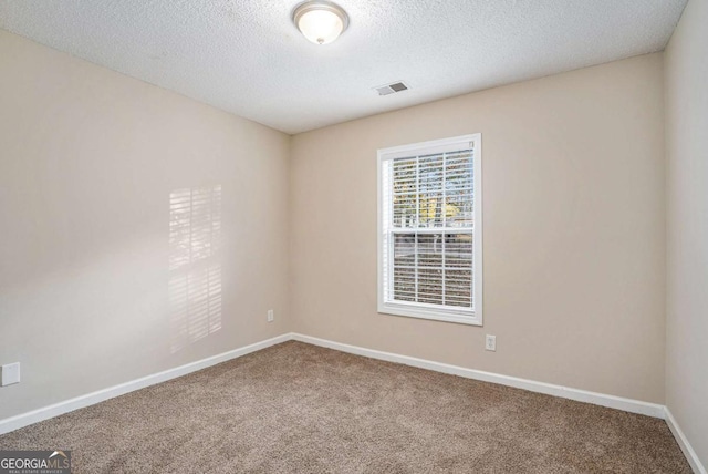 carpeted empty room with a textured ceiling