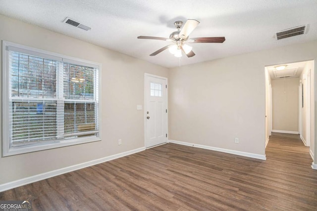 foyer entrance with a textured ceiling, dark hardwood / wood-style floors, and ceiling fan