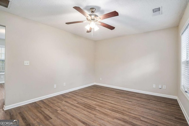 unfurnished room with dark hardwood / wood-style floors, ceiling fan, and a textured ceiling