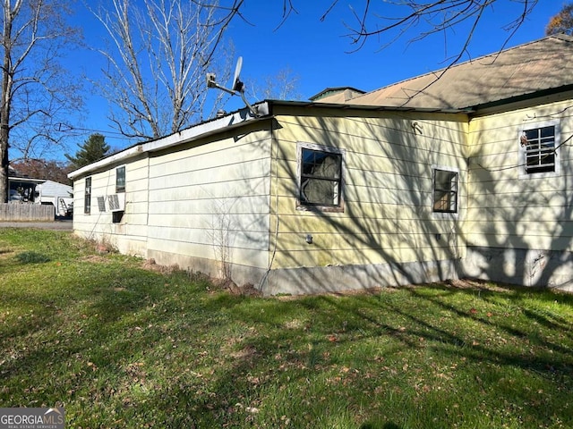 view of side of home with a yard