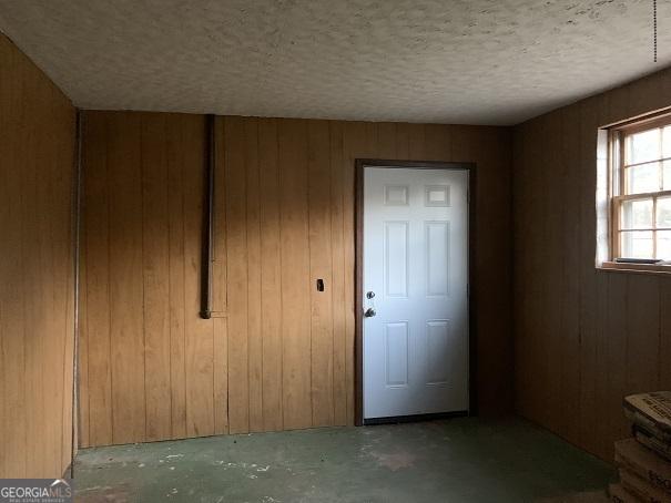 interior space with concrete flooring and wooden walls