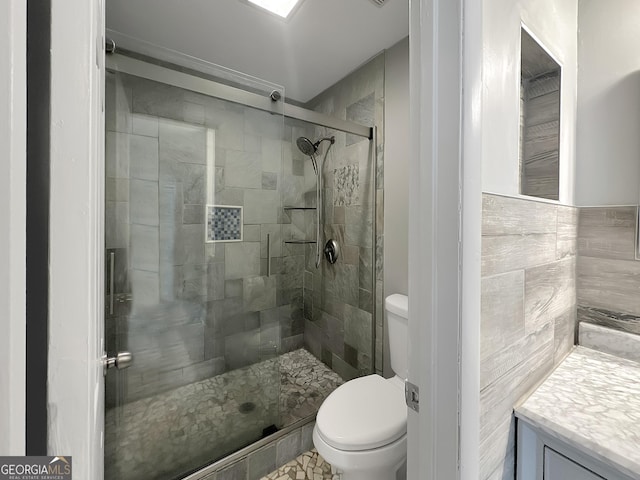 bathroom with vanity, toilet, and a shower with shower door