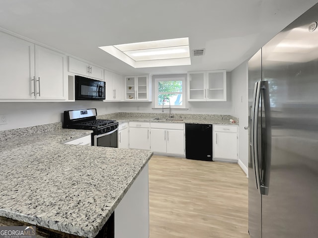 kitchen featuring black appliances, white cabinetry, and kitchen peninsula