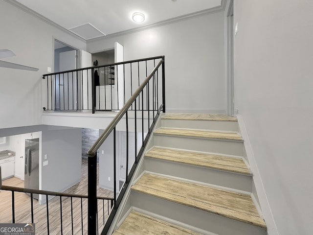 staircase featuring hardwood / wood-style flooring and crown molding