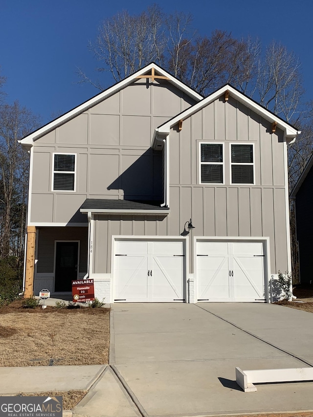 view of front facade featuring driveway, board and batten siding, and an attached garage