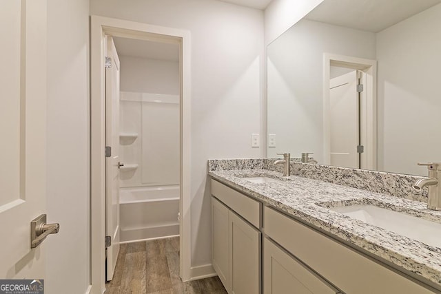 bathroom with hardwood / wood-style flooring, vanity, and shower / bath combination