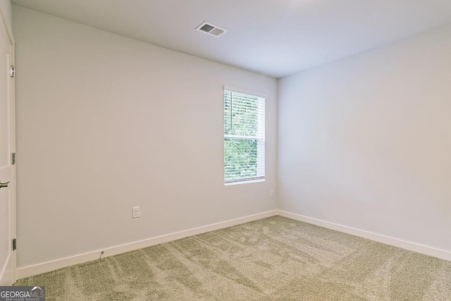 empty room featuring carpet floors, baseboards, and visible vents