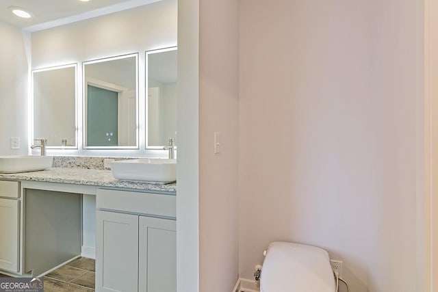 full bathroom with a sink, toilet, and double vanity