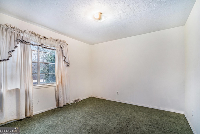 carpeted empty room featuring a textured ceiling