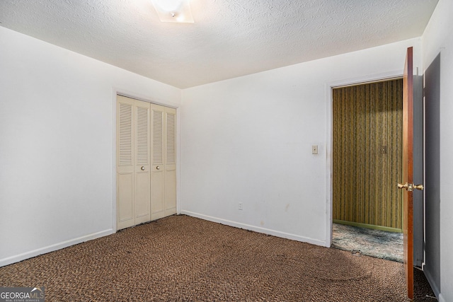 unfurnished bedroom featuring a closet, carpet, and a textured ceiling