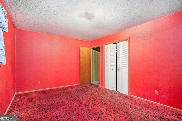 unfurnished bedroom with a textured ceiling, carpet floors, and a closet