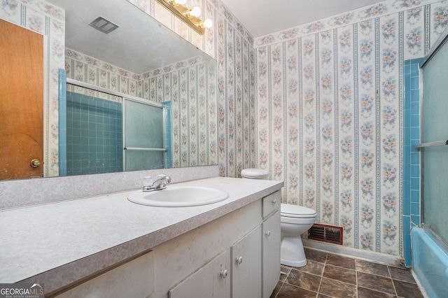 full bathroom featuring vanity, combined bath / shower with glass door, and toilet