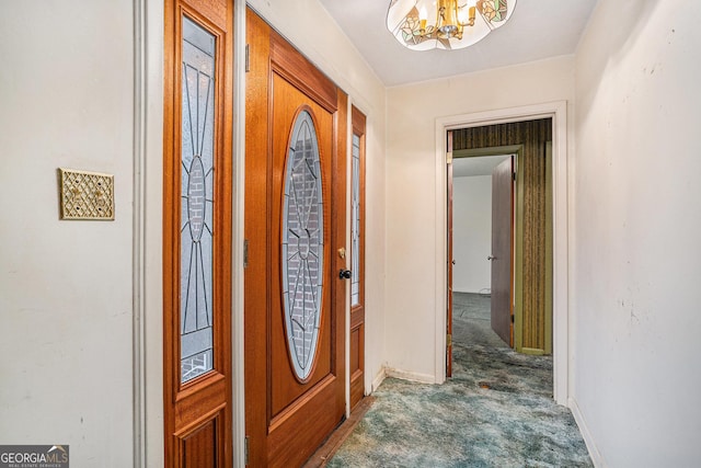 carpeted foyer entrance with an inviting chandelier